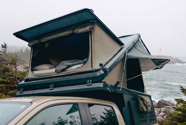 Chevrolet Colorado pop-up truck camper with the roof tent open at camp