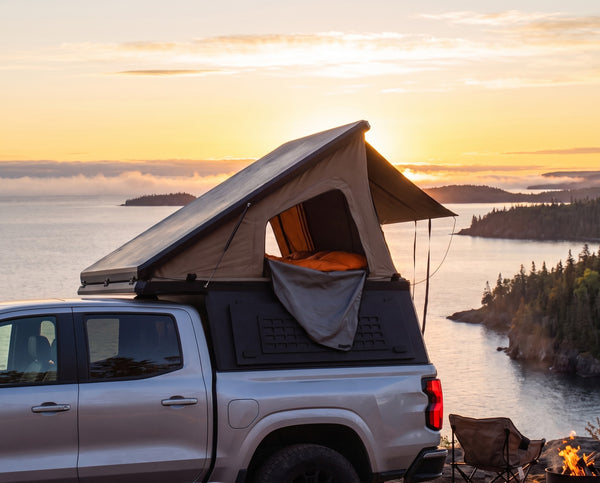 Chevrolet Colorado pop-up truck camper with the roof tent open at camp