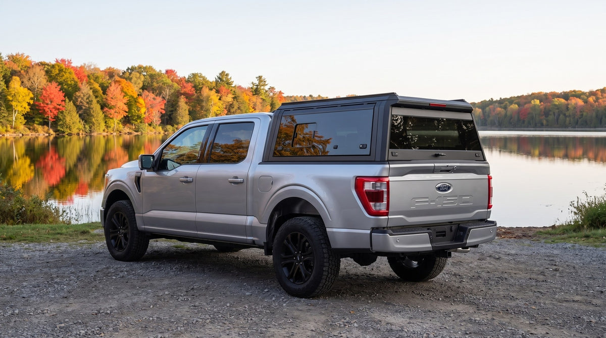 Wide view of a Ford F-150 with a windowed aluminum truck cap parked beside an Ontario lake in autumn