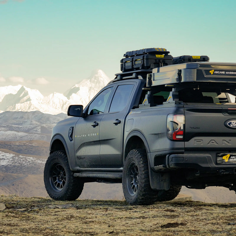 Ford Ranger with STORM roof rack, rear three-quarter view in the mountains
