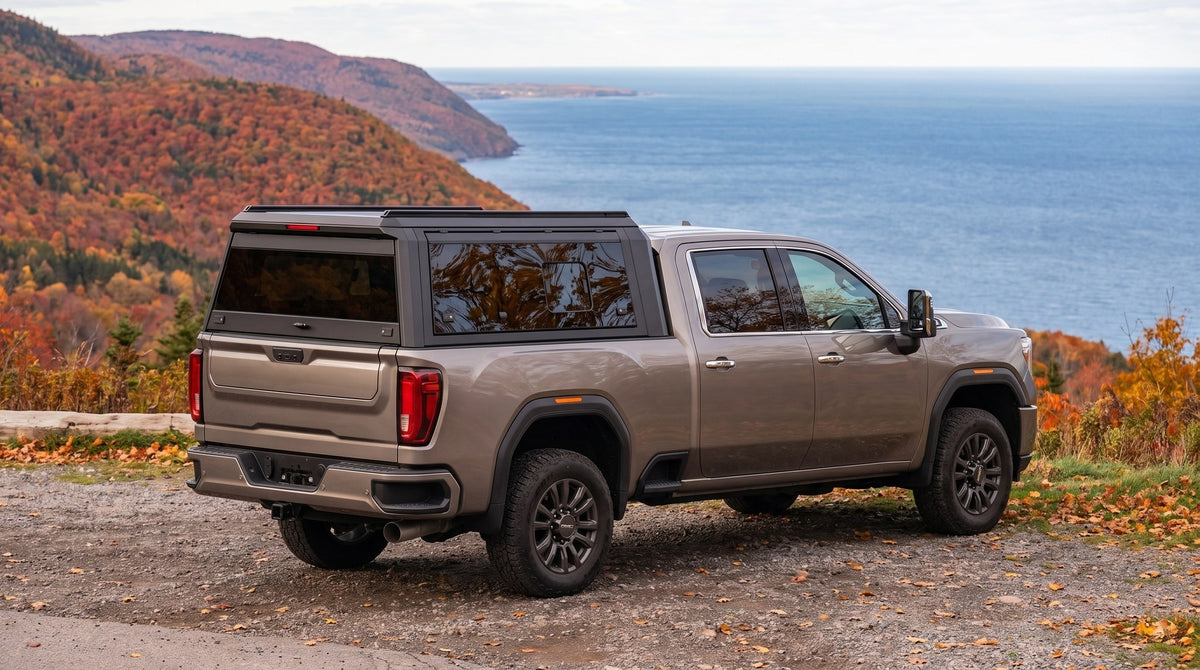 Wide view of a GMC Sierra 2500HD 3500HD with a windowed aluminum truck cap parked at a lookout on the Cabot Trail