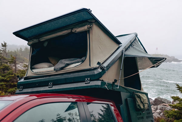 Toyota Tacoma pop-up truck camper with the roof tent open at camp