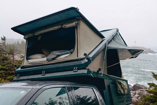 Toyota Tundra pop-up truck camper with the roof tent open at camp