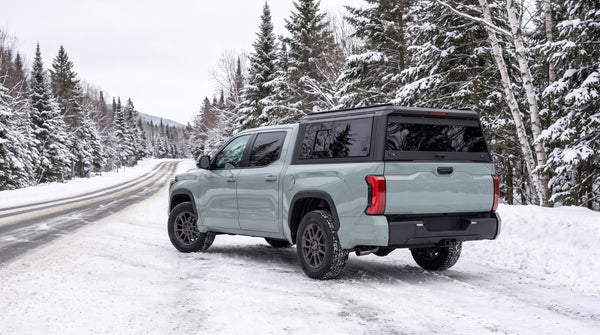 Toyota Tundra with an aluminum truck cap on a winter road
