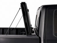 Cover folded fully upright against the cab, secured with prop rods — view 12