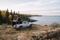 Wide view of a Chevrolet Colorado truck camper set up above the Lake Superior shoreline in autumn