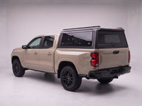Chevy Colorado truck cap with the honeycomb security guard showing through the tinted rear window, studio view