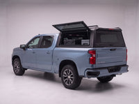Lift-up side window open on the Chevy Silverado 1500 truck cap, giving access to tool cases in the bed from beside the truck
