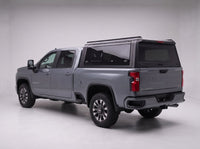 Matte black aluminum truck cap with tinted windows on a Chevy Silverado 2500HD 3500HD, studio rear three-quarter view