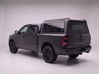 Dodge Ram 1500 truck cap with the honeycomb security guard showing through the tinted rear window, studio view