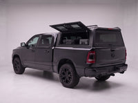 Lift-up side window open on the Dodge Ram 1500 truck cap, giving access to tool cases in the bed from beside the truck