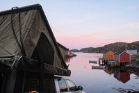 Side of the open roof tent on a Dodge Ram 2500/3500, overlooking a Newfoundland fishing cove at dawn (the side awning shown is not included)