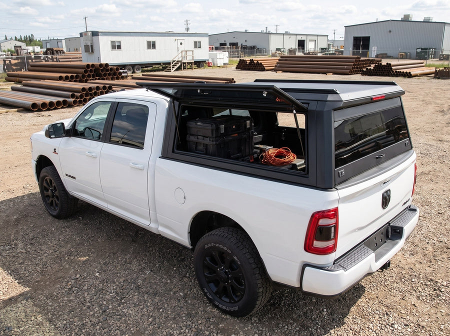 Dodge Ram 2500 3500 truck cap with the side window lifted open at a job site, tool cases and an extension cord inside