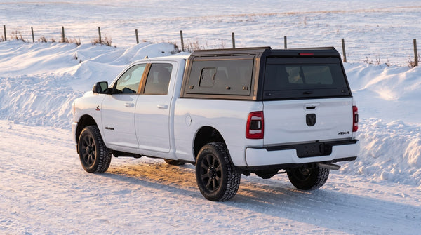 Dodge Ram 2500/3500 with an aluminum truck cap on a winter road