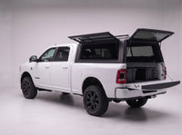 Rear door of the Dodge Ram 2500 3500 truck cap lifted open with the tailgate down and storage totes in the bed