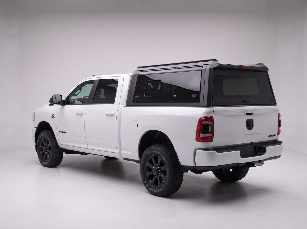Matte black aluminum truck cap with tinted windows on a Dodge Ram 2500 3500, studio rear three-quarter view