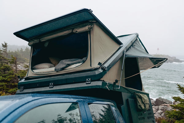 Ford F-150 pop-up truck camper with the roof tent open at camp