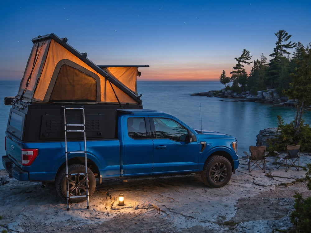 Ford F-150 pop-up truck cap camper glowing at dusk on the Georgian Bay shore with camp chairs and a lantern