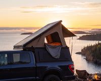 Ford F-150 pop-up truck cap camper with the roof tent open at sunset over Lake Superior