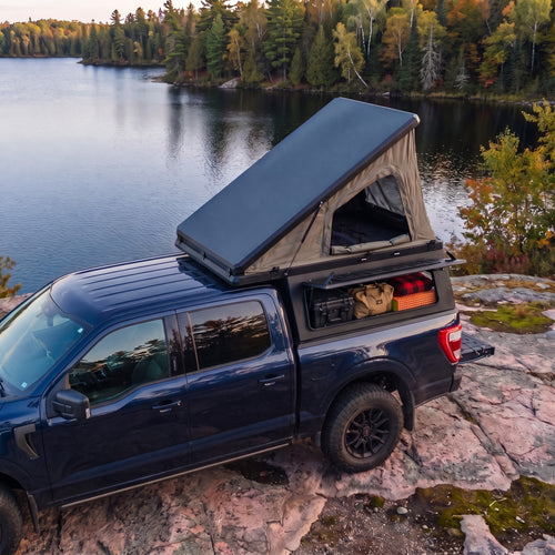 Ford F-150 Single Pop-Up truck cap camper with the roof tent open beside a northern Ontario lake