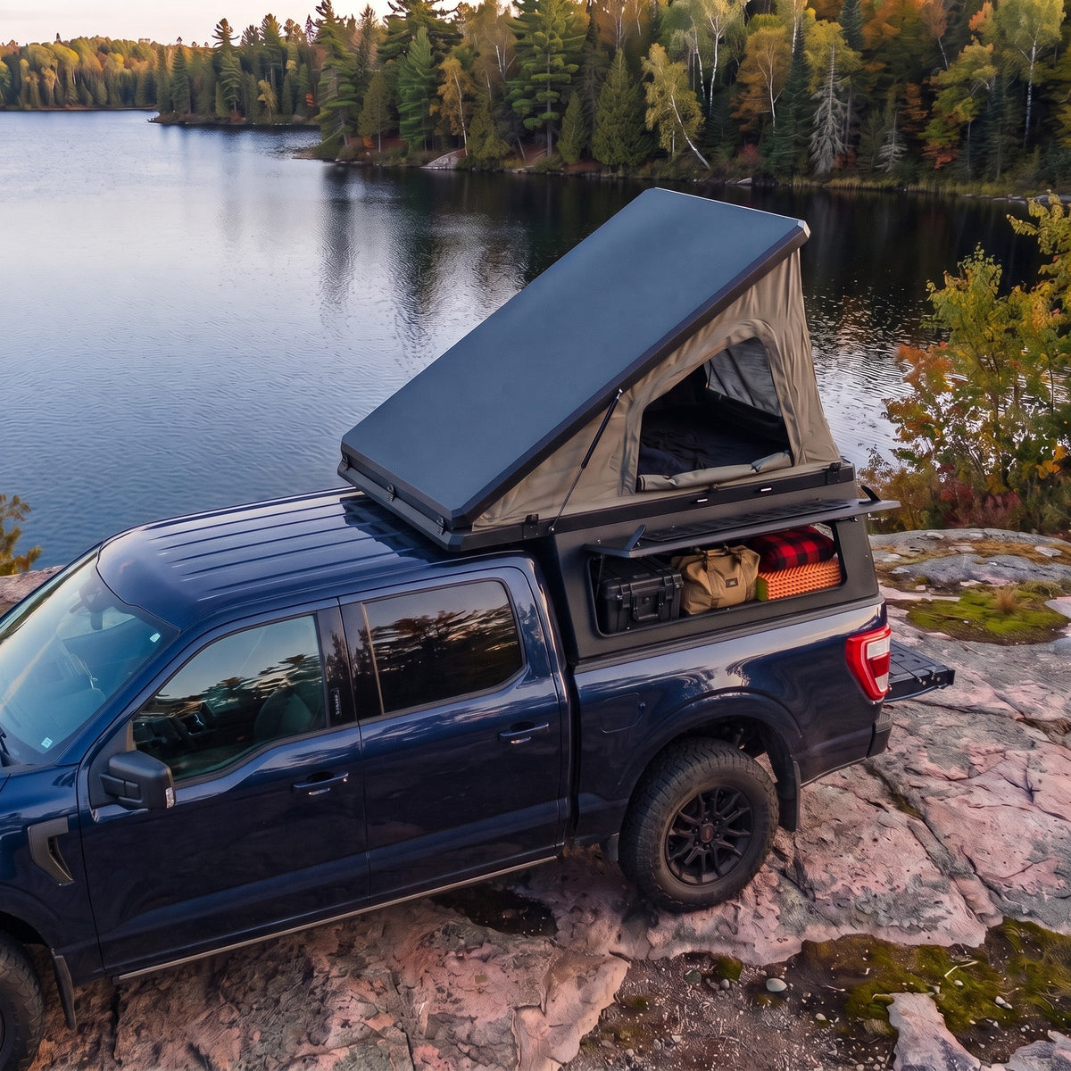 Ford F-150 Single Pop-Up truck cap camper with the roof tent open beside a northern Ontario lake