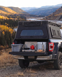 Tailgate camp kitchen under the rear hatch of a Ford F-150 truck bed camper