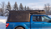 Ford F-150 truck cap camper closed up for winter driving on a snowy Ontario road