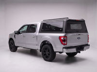 Ford F-150 truck cap with the honeycomb security guard showing through the tinted rear window, studio view