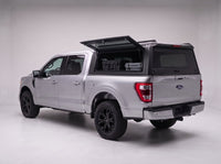 Lift-up side window open on the Ford F-150 truck cap, giving access to tool cases in the bed from beside the truck