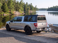 Ford F-150 with a windowed truck cap towing an aluminum fishing boat at a northern Ontario boat launch