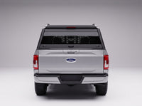 Straight-on rear view of the Ford F-150 truck cap with the honeycomb guard behind its full-width rear window and the LED third brake light