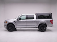 Side profile of a silver Ford F-150 fitted with the TruckTon aluminum truck cap with tinted windows