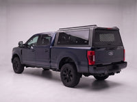 Ford F-250 F-350 Super Duty truck cap with the honeycomb security guard showing through the tinted rear window, studio view