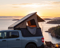 Ford Maverick pop-up truck cap camper with the roof tent open at sunset over Lake Superior