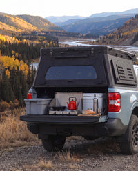 Tailgate camp kitchen under the rear hatch of a Ford Maverick truck bed camper