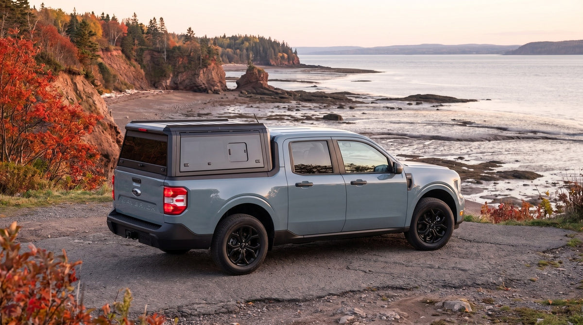 Wide view of a Ford Maverick with a windowed aluminum truck cap parked at a coastal road above the Bay of Fundy