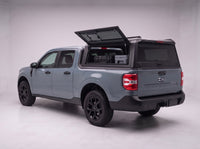 Lift-up side window open on the Ford Maverick truck cap, giving access to tool cases in the bed from beside the truck