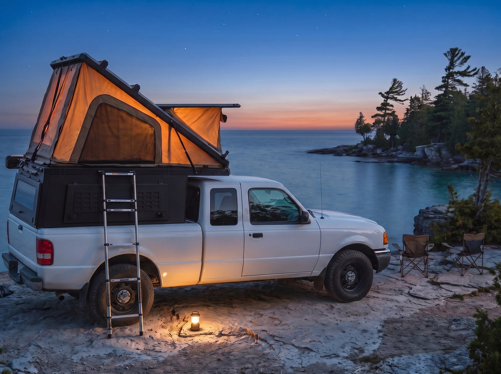 Ford Ranger pop-up truck cap camper glowing at dusk on the Georgian Bay shore with camp chairs and a lantern