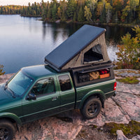 Ford Ranger Single Pop-Up truck cap camper with the roof tent open beside a northern Ontario lake