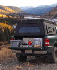 Tailgate camp kitchen under the rear hatch of a Ford Ranger truck bed camper