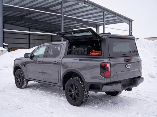 Ford Ranger with an aluminum truck cap on a winter road