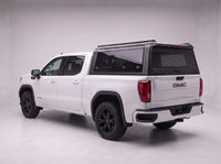 GMC Sierra 1500 truck cap with the honeycomb security guard showing through the tinted rear window, studio view