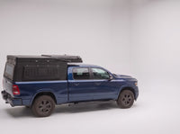 Step 1, closed for driving: the Double Pop-Up truck cap camper packed flat on a Ram 1500