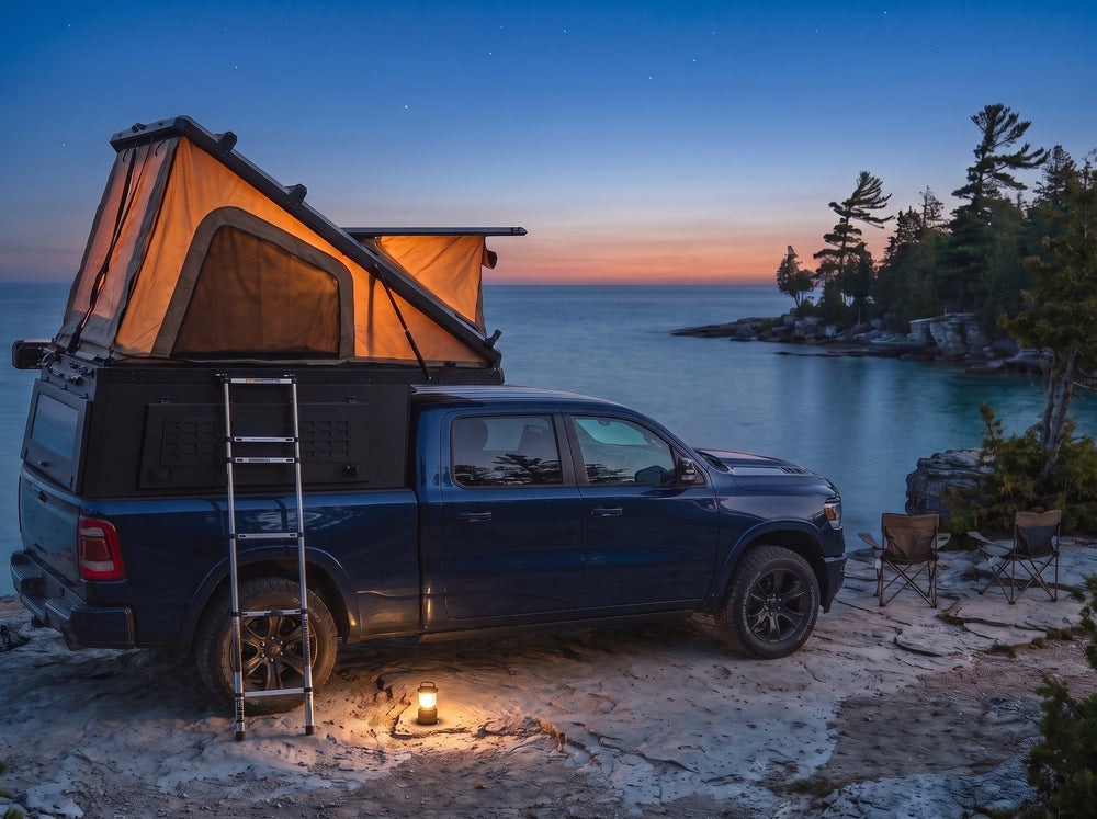 Ram 1500 pop-up truck cap camper glowing at dusk on the Georgian Bay shore with camp chairs and a lantern
