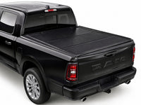 TruckTon hard flip-back tonneau cover closed on a RAM 1500 — low-profile matte black panels — view 1