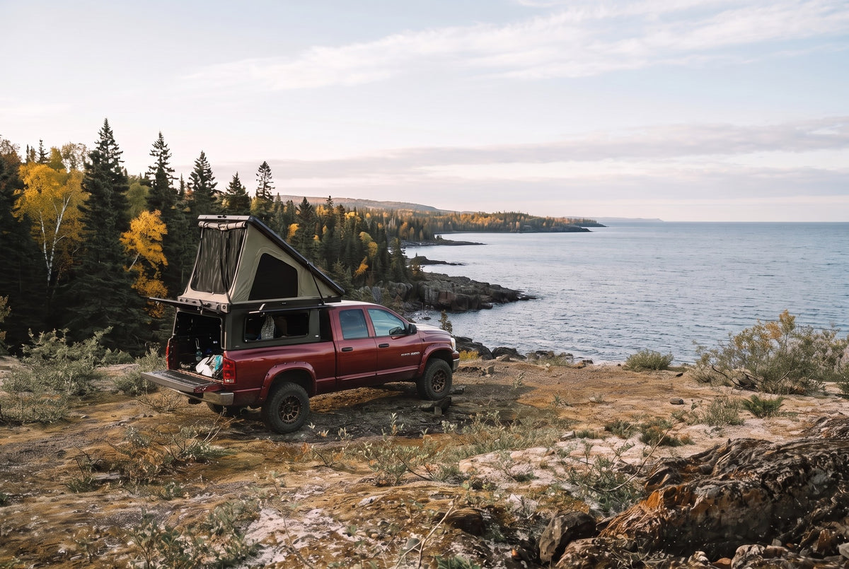 Wide view of a Dodge Ram 2500/3500 truck camper set up above the Lake Superior shoreline in autumn