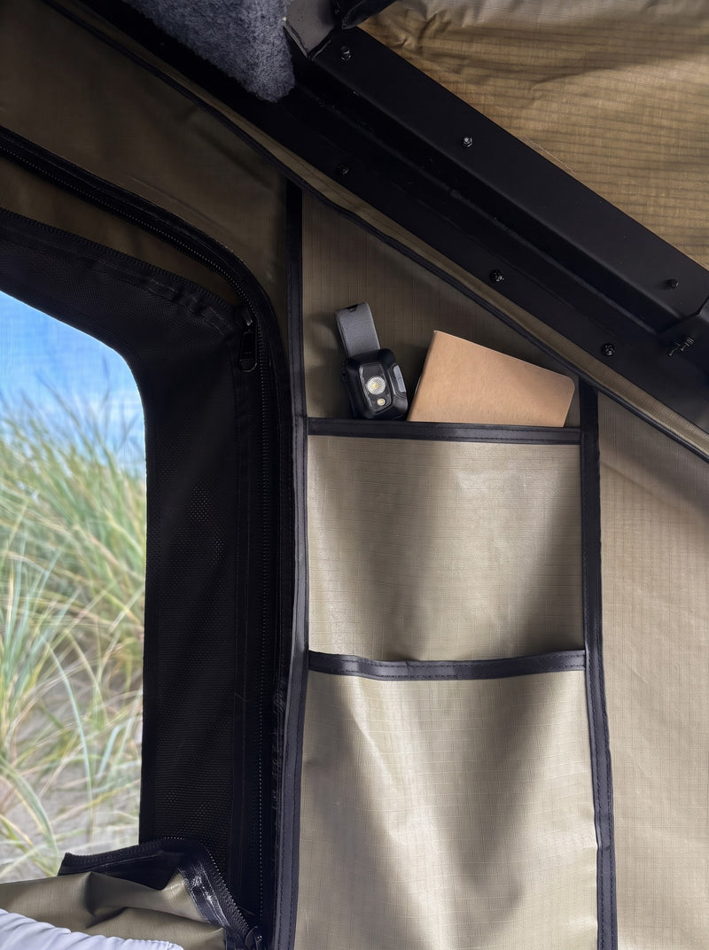 Sewn storage pockets and a zipped mesh window inside the roof tent