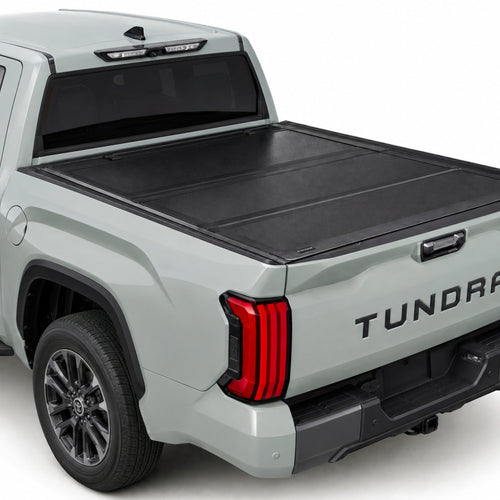 TruckTon hard flip-back tonneau cover closed on a Toyota Tundra — low-profile matte black panels