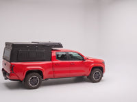 Step 1, closed for driving: the Double Pop-Up truck cap camper packed flat on a Toyota Tacoma
