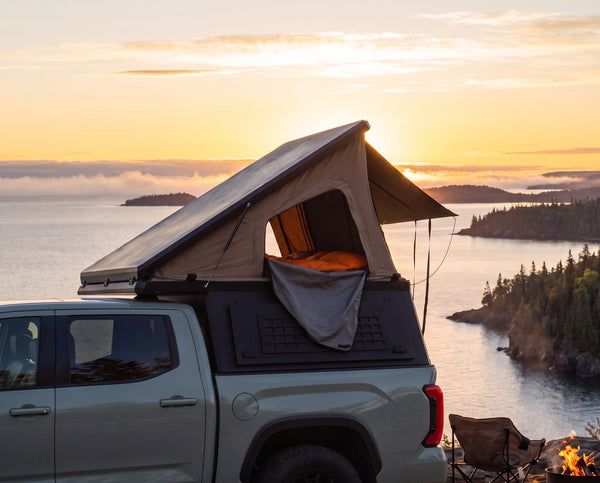 Toyota Tacoma pop-up truck camper with the roof tent open at camp